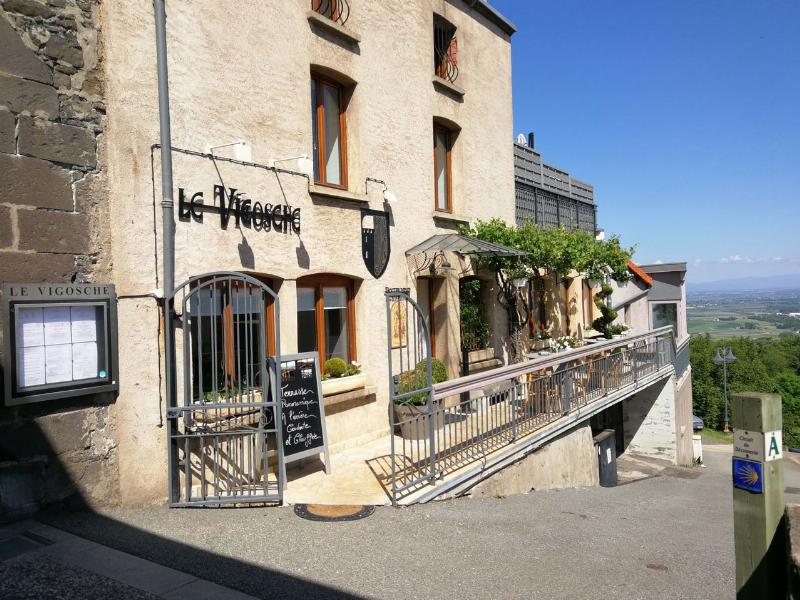 Un chef souriant présentant un plat de Truffade fumant et doré dans une cuisine moderne de Clermont-Ferrand